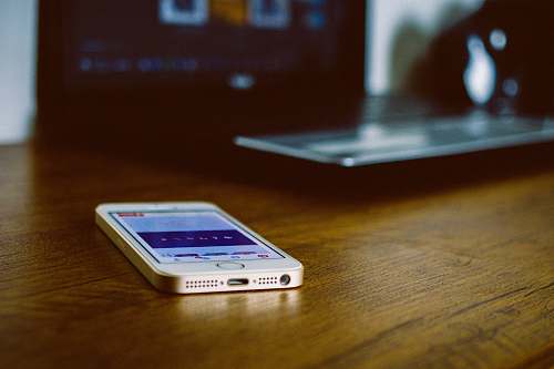 phone silver iPhone 5s on brown wooden desk iphone